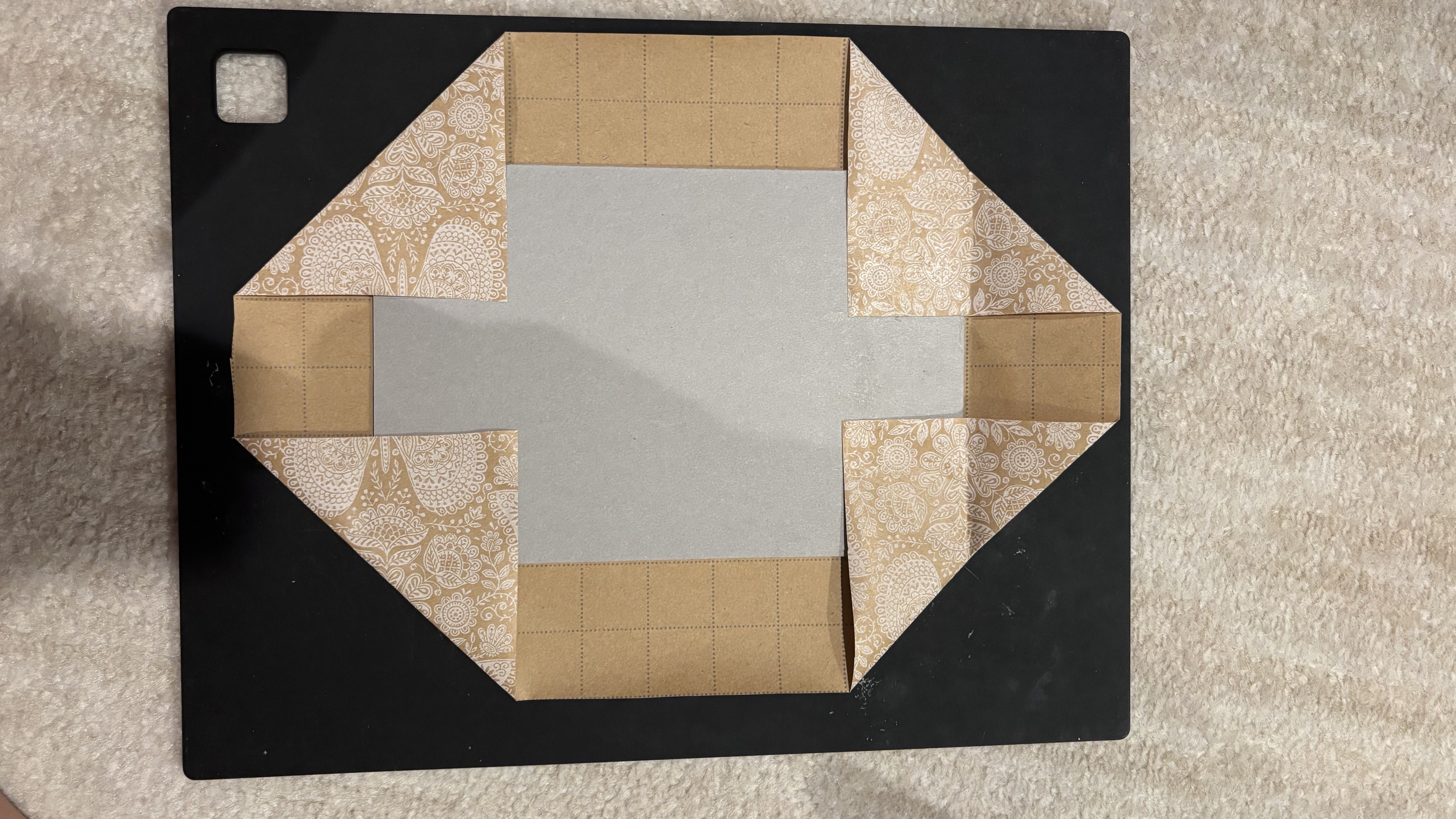 Folding decorative paper corners around the cardboard
